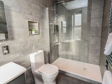 A bathroom with a shower, toilet, and sink at Rose House in Alnmouth
