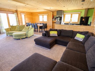 A living room with sofas and a dining table near a kitchen at iLodge Ultra Kenwick near Louth