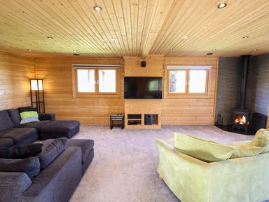 A living room with sofas a fireplace a television and windows at iLodge Ultra in Kenwick near Louth