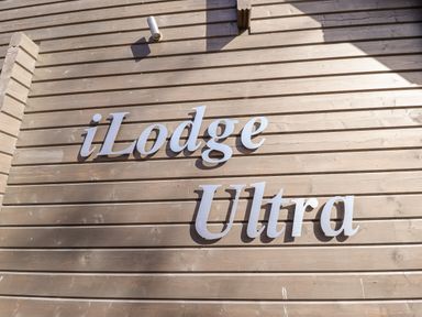Metal letters spelling iLodge Ultra on a wooden exterior wall at iLodge Ultra Kenwick near Louth