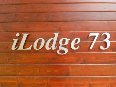 A wooden wall with the text iLodge 73 at iLodge 73 Kenwick near Louth