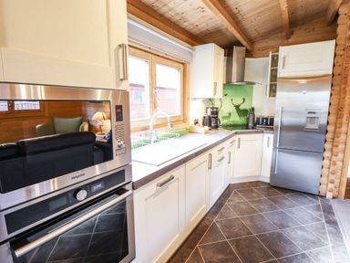A kitchen with white cabinets stainless steel appliances and a window with wooden frame at iLodge 73 Kenwick near Louth