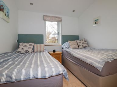 A bedroom with two single beds and a window between them at 10 Faraway Fields in Dobwalls