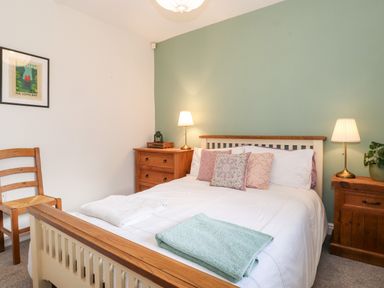 A bedroom with a double bed and bedside tables with lamps at Garden Cottage in Chathill near Beadnell
