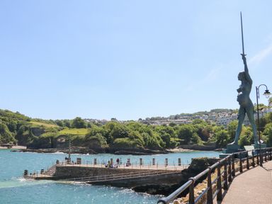 A coastal pier with people fishing and a statue holding a sword at Beach View in Combe Martin