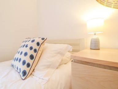 A bedroom with a bed pillow and a nightstand with a lamp at Feathers Blythburgh in Reydon