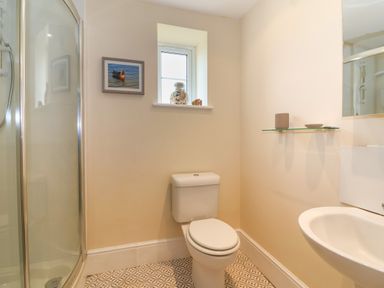 A bathroom with a toilet shower enclosure sink mirror and small window at Canny Croft in Chilton Polden near Street