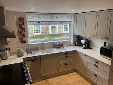 A kitchen with a sink and coffee machine at Woodbine Cottage Mylor Bridge Nr Falmouth
