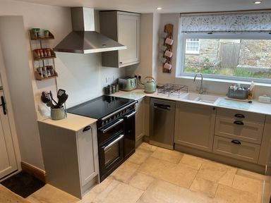 A kitchen with stove, sink and cupboard at Woodbine Cottage, Mylor Bridge, Nr Falmouth