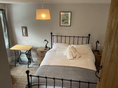 A bedroom with a bed and bedside tables at Woodbine Cottage, Mylor Bridge, Nr Falmouth