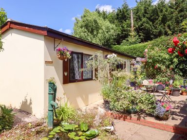 A house with a garden featuring a table and chairs at Turnpike Lodge in Brixham