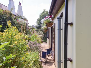 A garden with flowers and a chair at Turnpike Lodge in Brixham