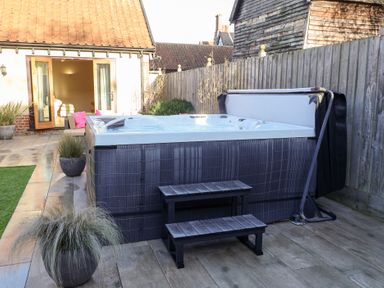A garden with a hot tub and outdoor step at The Stables at Hall Barn Wattisfield near Walsham-Le-Willows