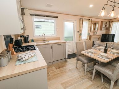 A kitchen and dining area with a table set for four and a television at 20 Wolds View in East Heslerton near West Heslerton
