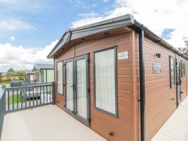 An exterior view of a wooden cabin with glass doors and windows on a deck at 20 Wolds View East Heslerton near West Heslerton