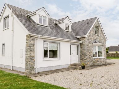 A detached house with mixed stone and white walls and a gravel driveway at The Glen in Carndonagh County Donegal