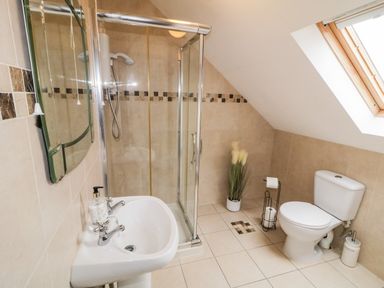 A bathroom with a shower cubicle sink and toilet under a skylight window at The Glen in Carndonagh County Donegal