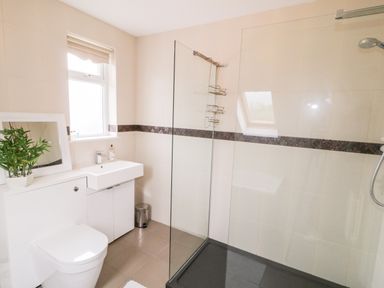 A bathroom with a toilet sink mirror glass shower at The Glen in Carndonagh County Donegal