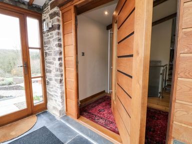 Front entrance with wooden door and glass side panel at Birchenhayes in St Dominick