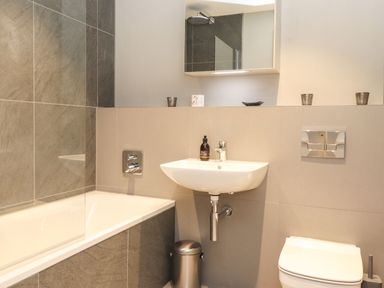 A bathroom with a bathtub sink and toilet at Bruach in Backbarrow