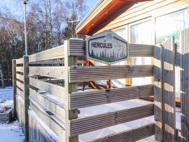 A wooden fence with a sign reading Hercules outside a building with large windows at Felmoor Park