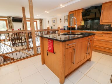 A kitchen with a wooden island and black countertop at Monkleigh Mill in Monkleigh near Bideford