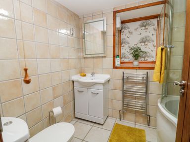 A bathroom with a toilet sink mirror towel rack bath and window at Monkleigh Mill Monkleigh near Bideford