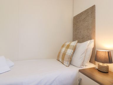 A bed with pillows and a bedside table with a lamp in a bedroom at Draco in Felmoor Park