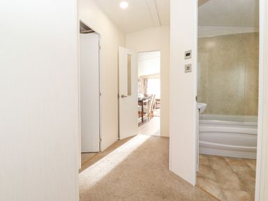 Hallway with doors leading to a bathroom and a dining area at Draco in Felmoor Park