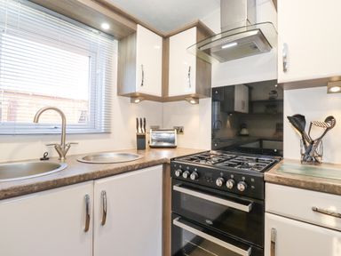 A kitchen with a double sink stove toaster and utensils at Ursa in Felmoor Park