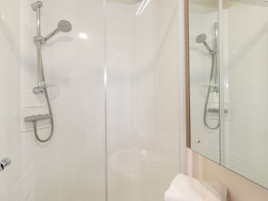 A bathroom with a shower and a mirror reflecting the shower at Ursa in Felmoor Park