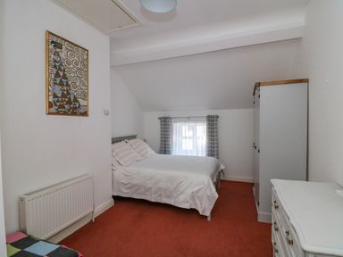 A bedroom with a bed, a wardrobe, a chest of drawers, and a framed artwork on the wall at 83 Upper John Street in Wexford Town County Wexford