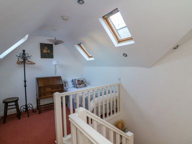 A bedroom with a single bed, wooden bureau, coat rack, and two skylight windows at 83 Upper John Street in Wexford Town County Wexford