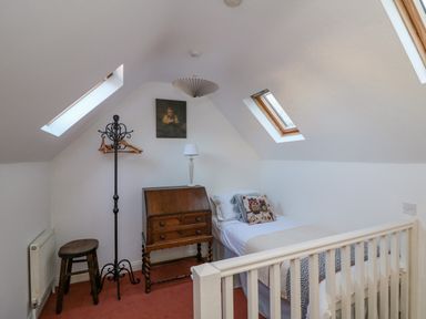 A bedroom with a single bed a wooden desk a coat rack a stool and two skylight windows at 83 Upper John Street in Wexford Town County Wexford