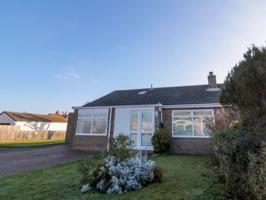 A single story house with a driveway and front garden at Barnacles in Boulmer near Longhoughton