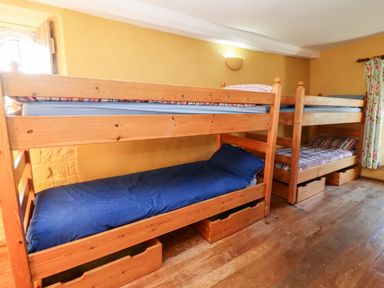 A bedroom with two wooden bunk beds and storage drawers underneath at Wick Court Farm Arlingham near Frampton On Severn