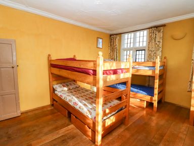 A bedroom with two wooden bunk beds and floral curtains at Wick Court Farm Arlingham near Frampton On Severn
