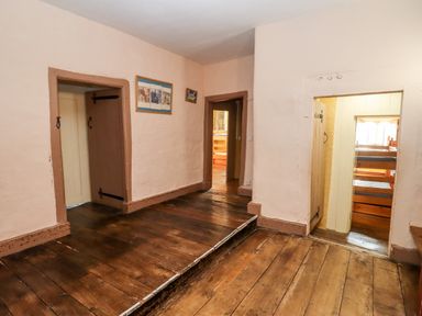A hallway with wooden floors and doorways leading to other rooms at Wick Court Farm in Arlingham near Frampton On Severn
