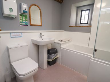A bathroom with a toilet sink bathtub mirror and a window at Wick Court Farm in Arlingham near Frampton On Severn