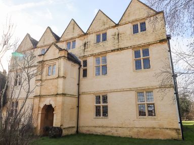 Exterior of a large historic yellow brick building with gable roofs and multiple windows at Wick Court Farm Arlingham near Frampton On Severn