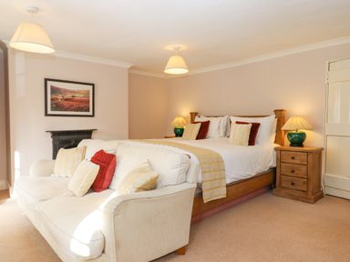A bedroom with a bed pillows lamps and a sofa at Early Mist Cottage in Haytor Vale