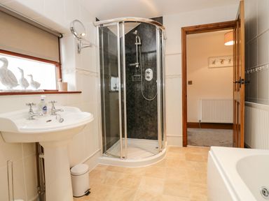 A bathroom with a shower enclosure sink and bathtub at The Anvil in Broughton-In-Furness