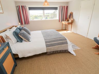 A bedroom with a bed pillows a side table and a dressing table at Whiteadder Bank in Berwick-Upon-Tweed