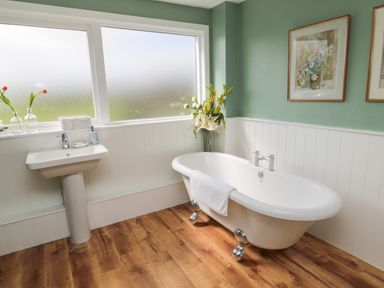 A bathroom with a clawfoot bathtub and a pedestal sink at Whiteadder Bank in Berwick-Upon-Tweed