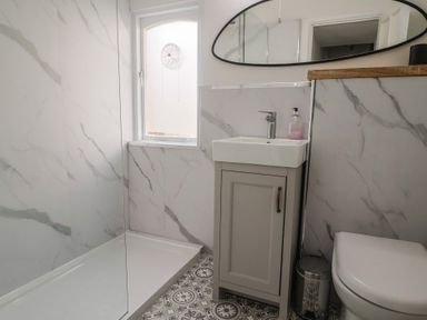 A bathroom with a shower and sink at Riverdance Cottage in Lyme Regis