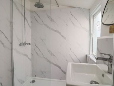 A bathroom with a shower and sink at Riverdance Cottage in Lyme Regis