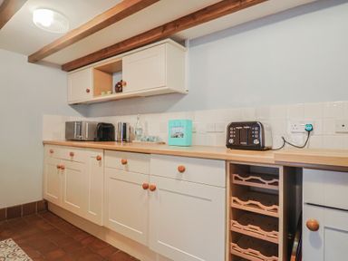 A kitchen with cabinets and appliances at Riverdance Cottage in Lyme Regis