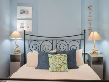 A bedroom with a bed and lamps at Riverdance Cottage in Lyme Regis
