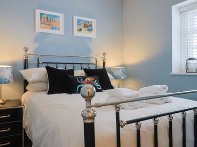 A bedroom with a bed and bedside table at Riverdance Cottage in Lyme Regis