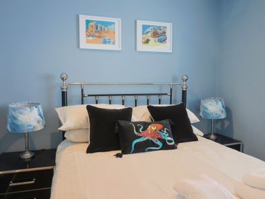 A bedroom with a bed and bedside lamps at Riverdance Cottage in Lyme Regis
